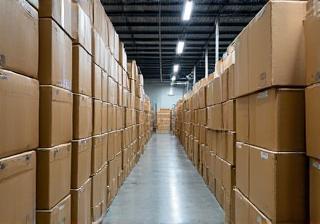 Boxes of audio equipment stacked in a modern warehouse